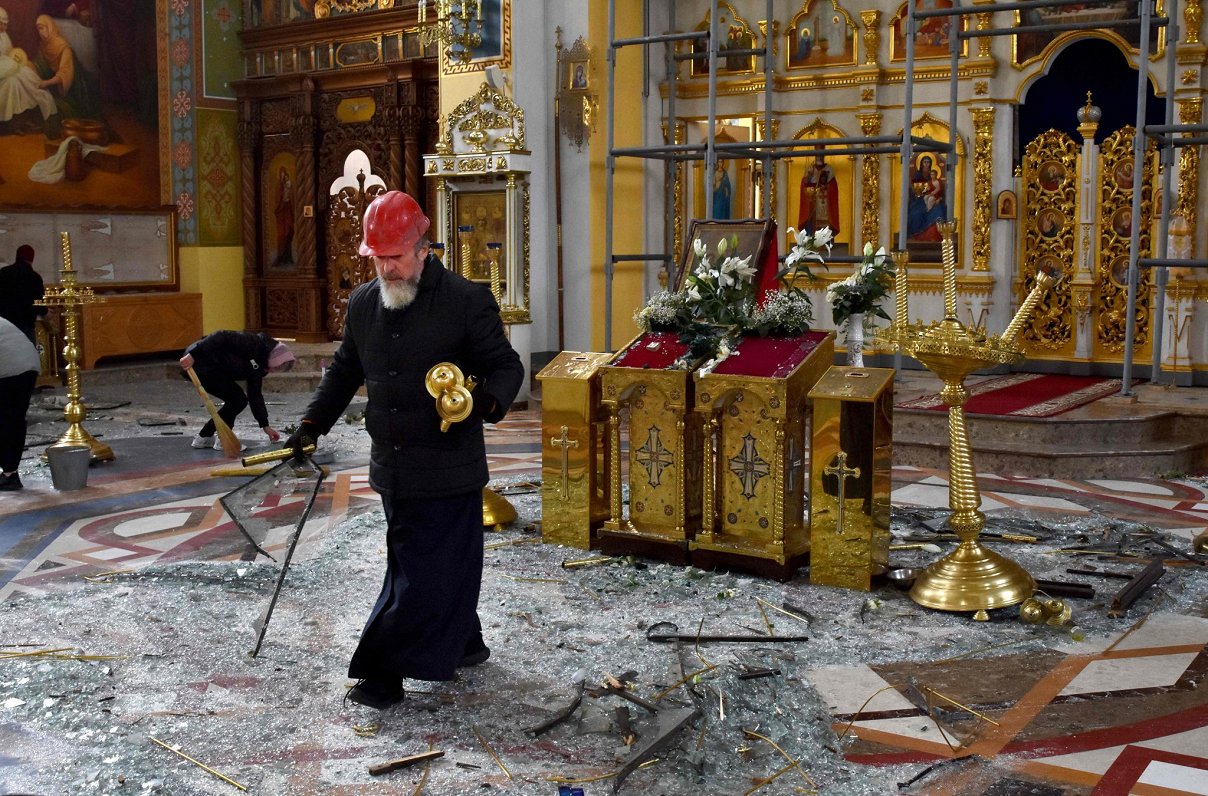 Ukrainas pilsētā Zaporižjā pareizticīgo garīdznieks aplūko postījumus baznīcā pēc Krievijas raķešu t...