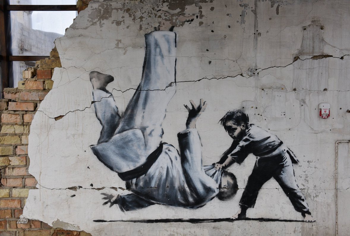Ielu mākslinieka Benksija zīmējums uz karadarbībā izpostīta nama sienas Ukrainas pilsētā Borodjankā