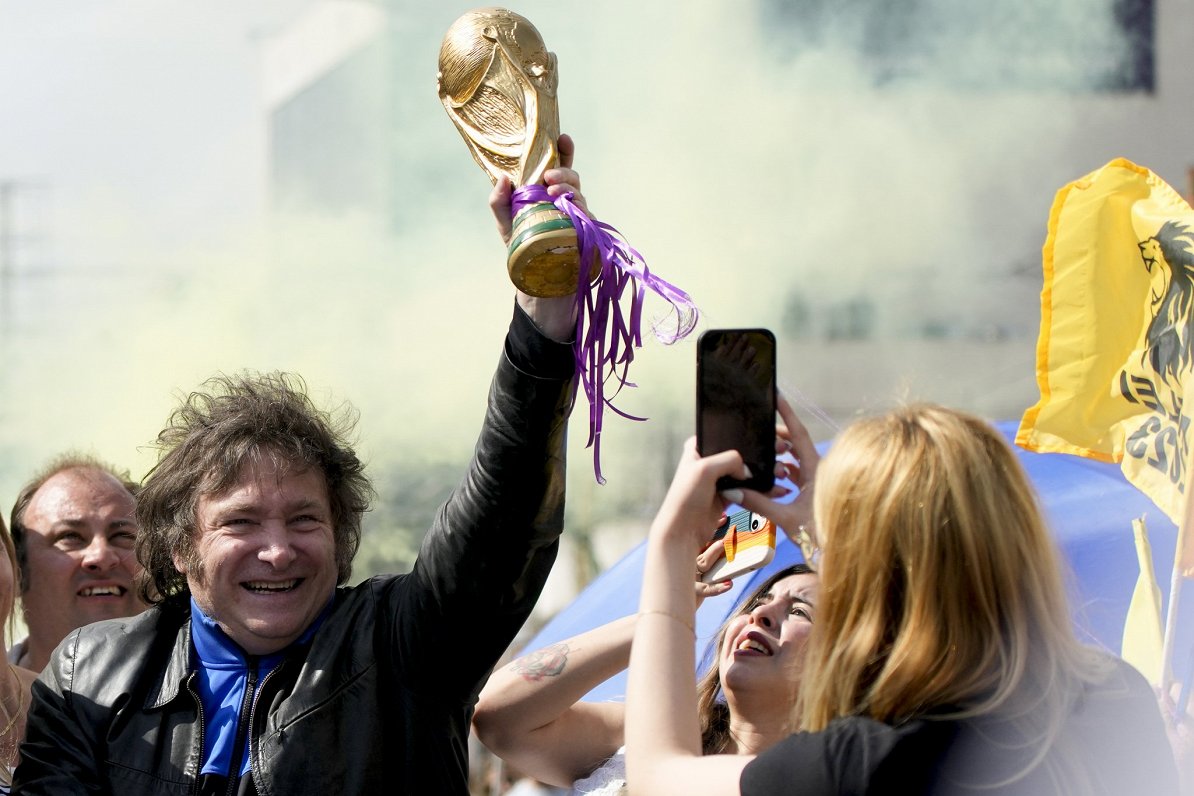 Argentīnas politiķis Havjers Milejs ar Argentīnas futbola izlases pērn izcīnītā Pasaules kausa kopij...