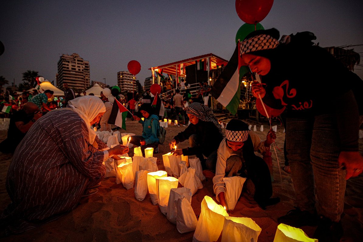 cilvēki Beirūtas pludmalē ar svecītēm piemin Gazas joslā cietušos civiliedzīvotājus