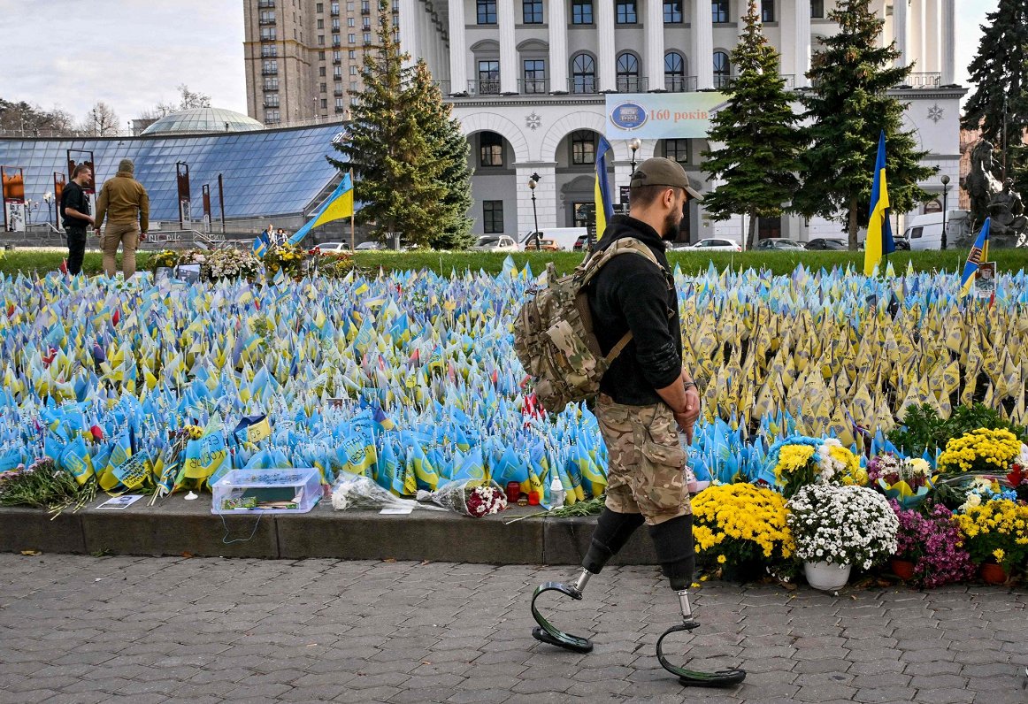 Vīrietis ar kāju protēzēm apmeklē memoriālu Neatkarības laukumā Kijivā