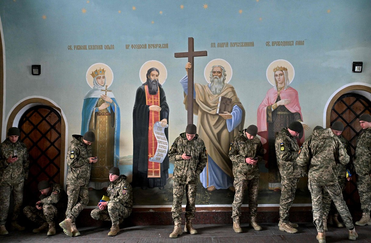Ukrainas armijas karavīri patveras no lietus katedrālē