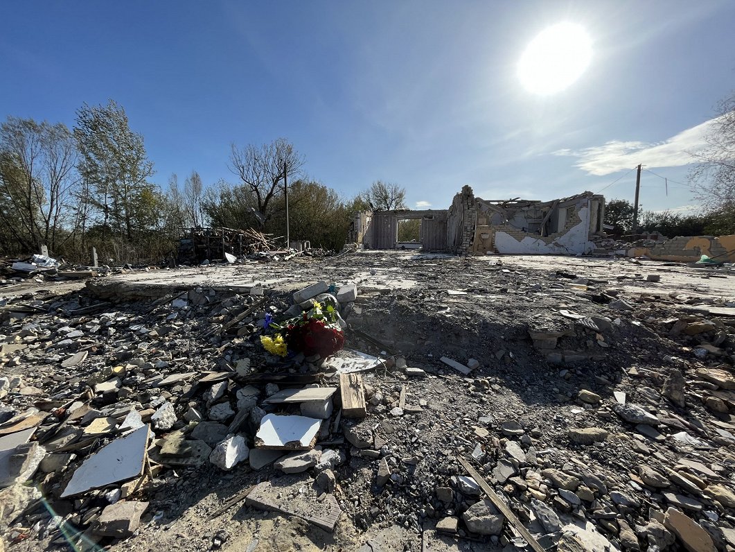 Ziedi, kas nolikti Krievijas raķetes triecienā izpostītās kafejnīcas vietā Hrozas ciemā Ukrainā