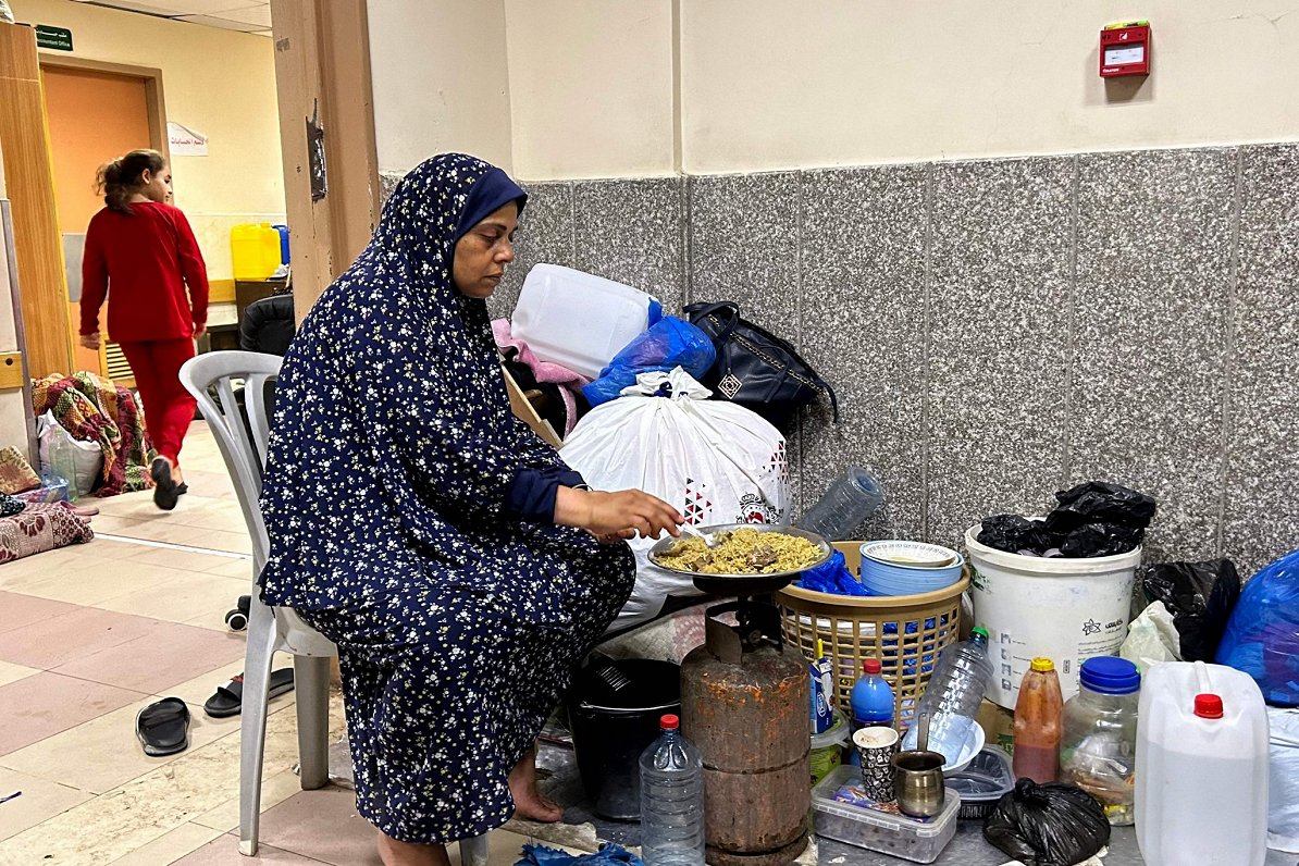 Palestīniešu sieviete, kas patvērusies Al-Šifas slimnīcā Gazas joslā gatavo ēst ārstniecības iestāde...