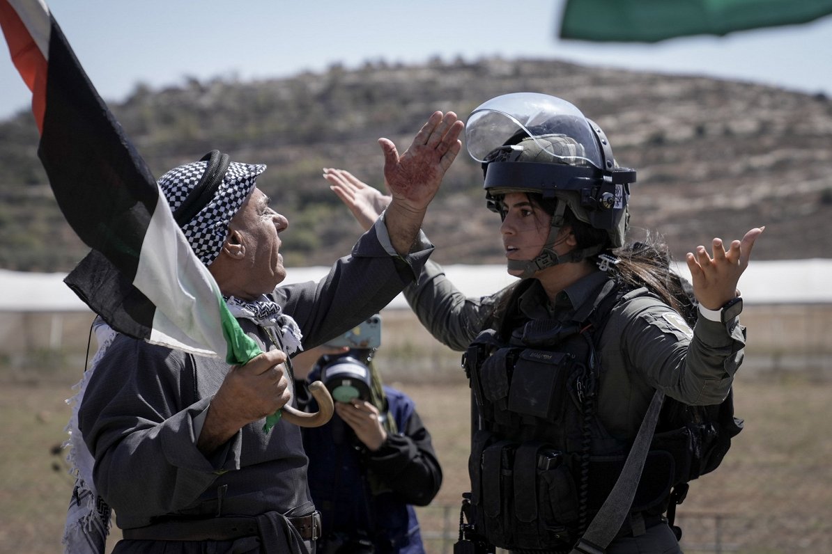 Palestīniešu vīrietis diskutē ar Izraēlas drošības spēku kareivi. Palestīnieši protestē pret ebreju...