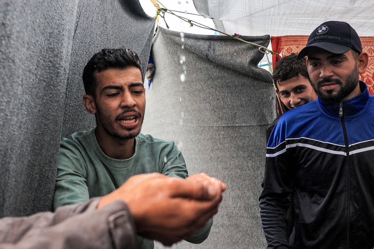 Palestīniešu bēgļu nometnē vīrieši dzer no jumta savākto lietusūdeni, jo Gazas joslā trūkst dzeramā...