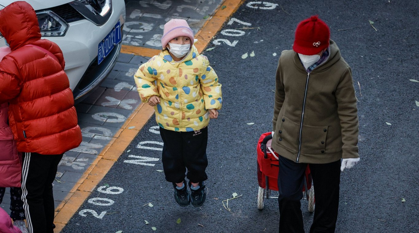Cilvēki sejas maskās Pekinā. 2023. gada novembris