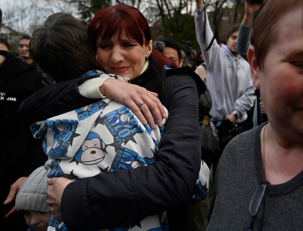 Ilustratīvs attēls: sieviete Ukrainas galvaspilsētā Kijivā apskauj dēlu, kas kopā ar vairāk nekā duc...