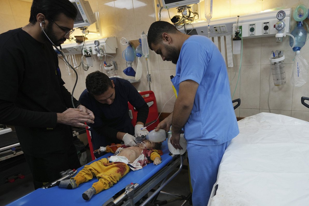 Gazas joslā mediķi palīdz palestīniešu bērnam, kas ievainots Izraēlas uzbrukumā