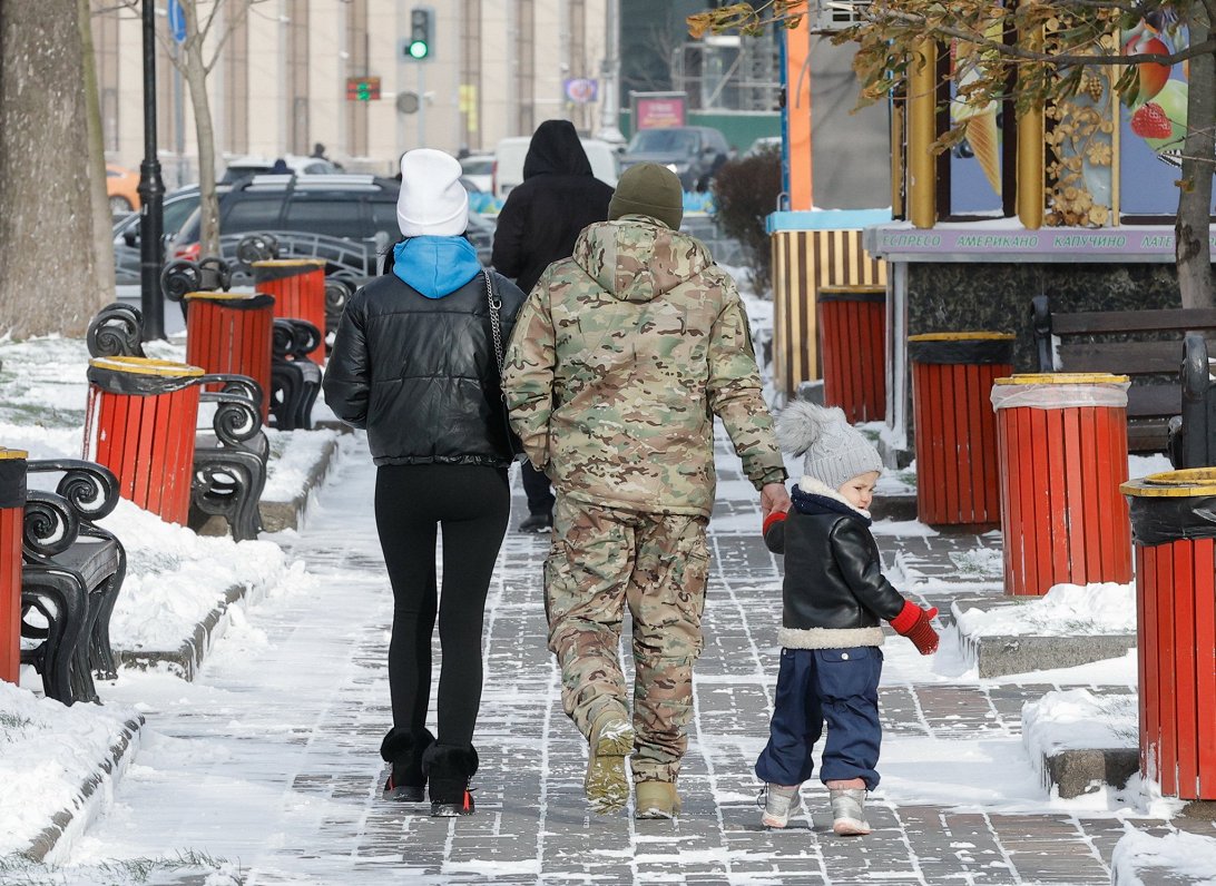 Ukraiņu ģimene dodas pastaigā pa sniegoto Kijivu.