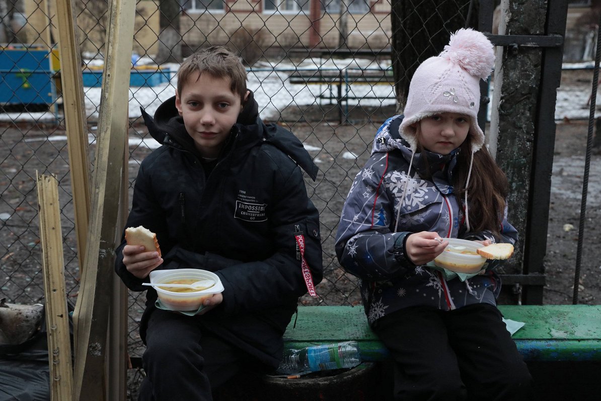 Ukrainas galvaspilsētā Kijivā bērni saņem siltu maltīti pēc tam, kad Krievijas raķešu uzbrukuma rezu...