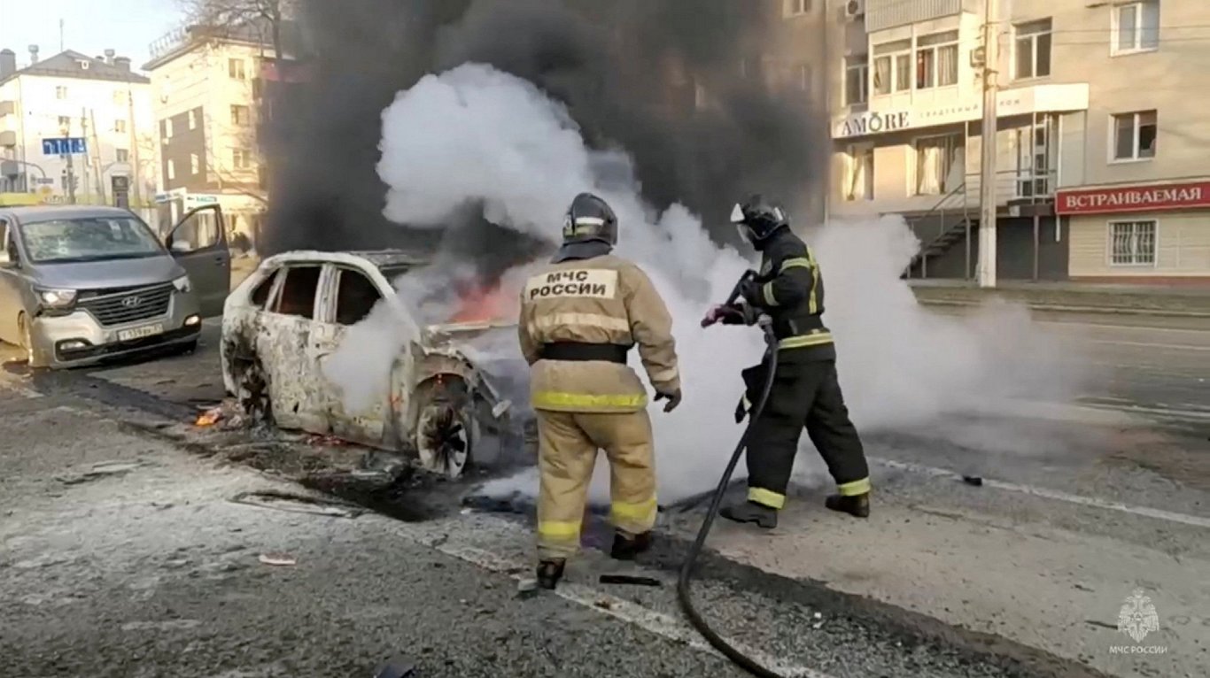 Krievijas pilsētā Belgorodā ugunsdzēsēji dzēš apšaudē cietušu automašīnu