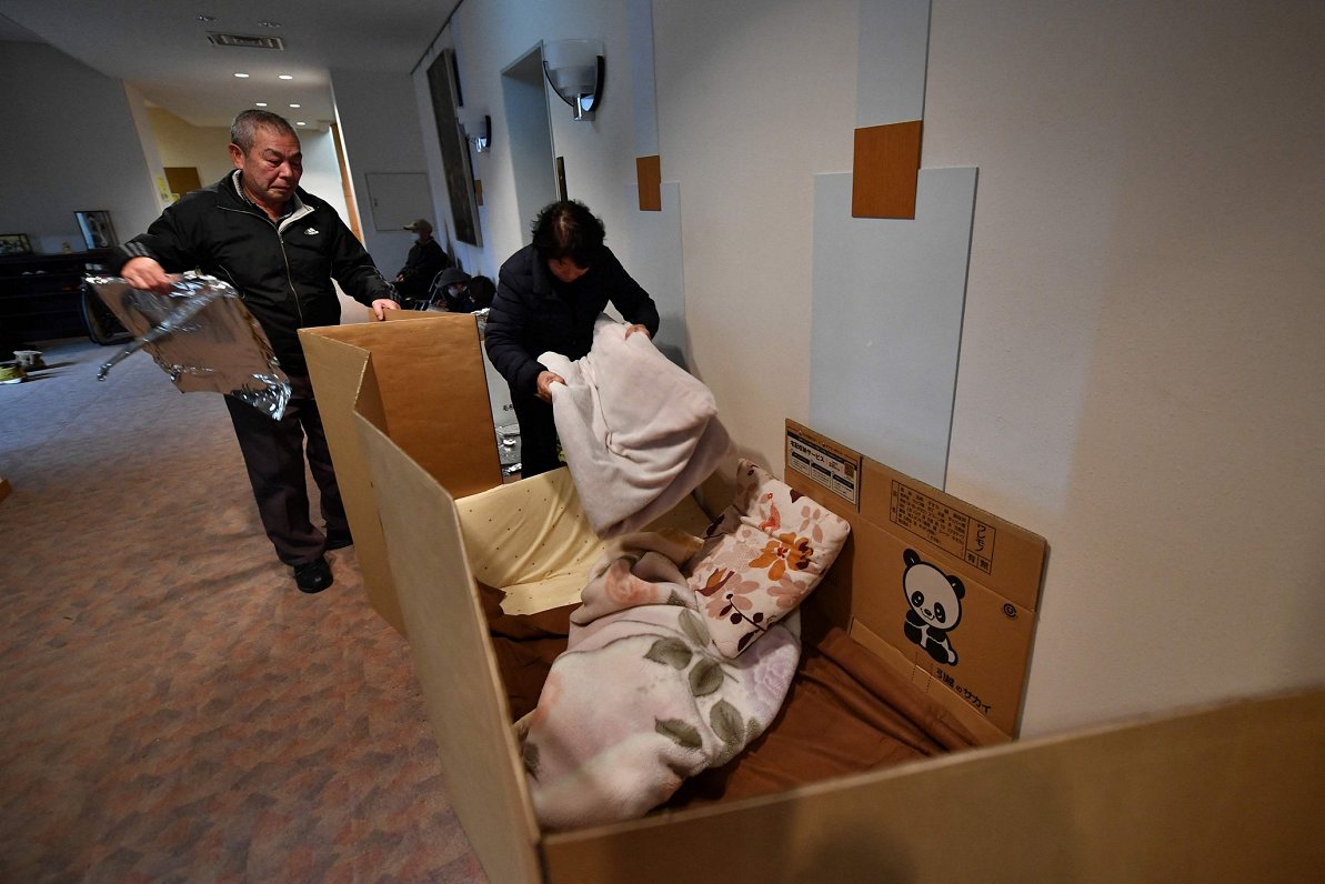 Japānas iedzīvotāju pāris iekārto pagaidu gultu patversmē Nanao pilsētā