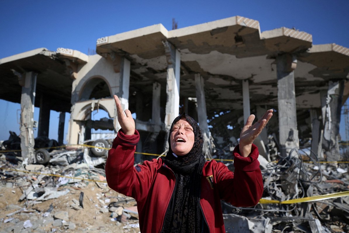 Palestīniešu sieviete pie Izraēlas uzbrukumā izpostītas ēkas Gazas joslā