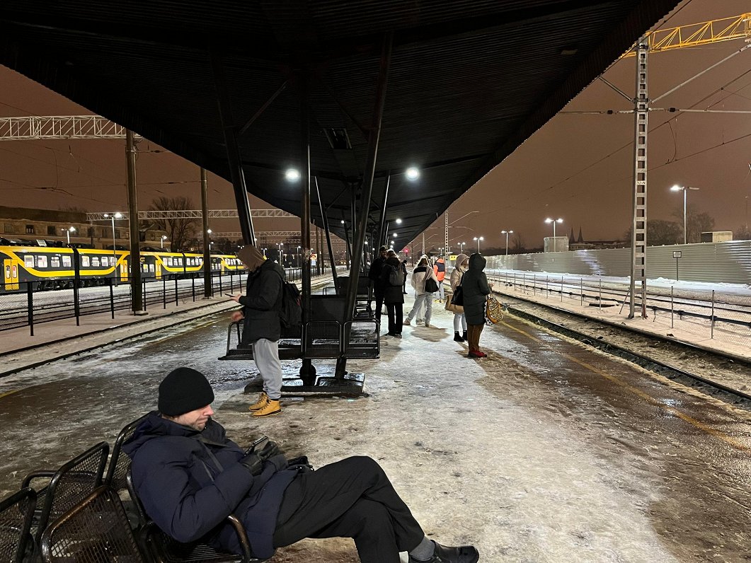 Cilvēki Rīgas stacijā gaida vilcienu