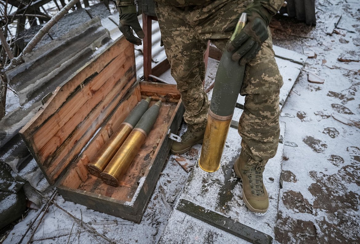 Ukraiņu karavīrs gatavo lādiņus, lai izšautu no haubices L119 uz Krievijas karaspēku netālu no Bahmu...