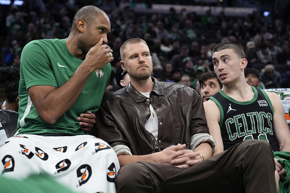 Kristaps Porziņģis (centrā) uz &quot;Celtics&quot; rezervistu soliņa NBA spēlē pret &quot;Clippers &...