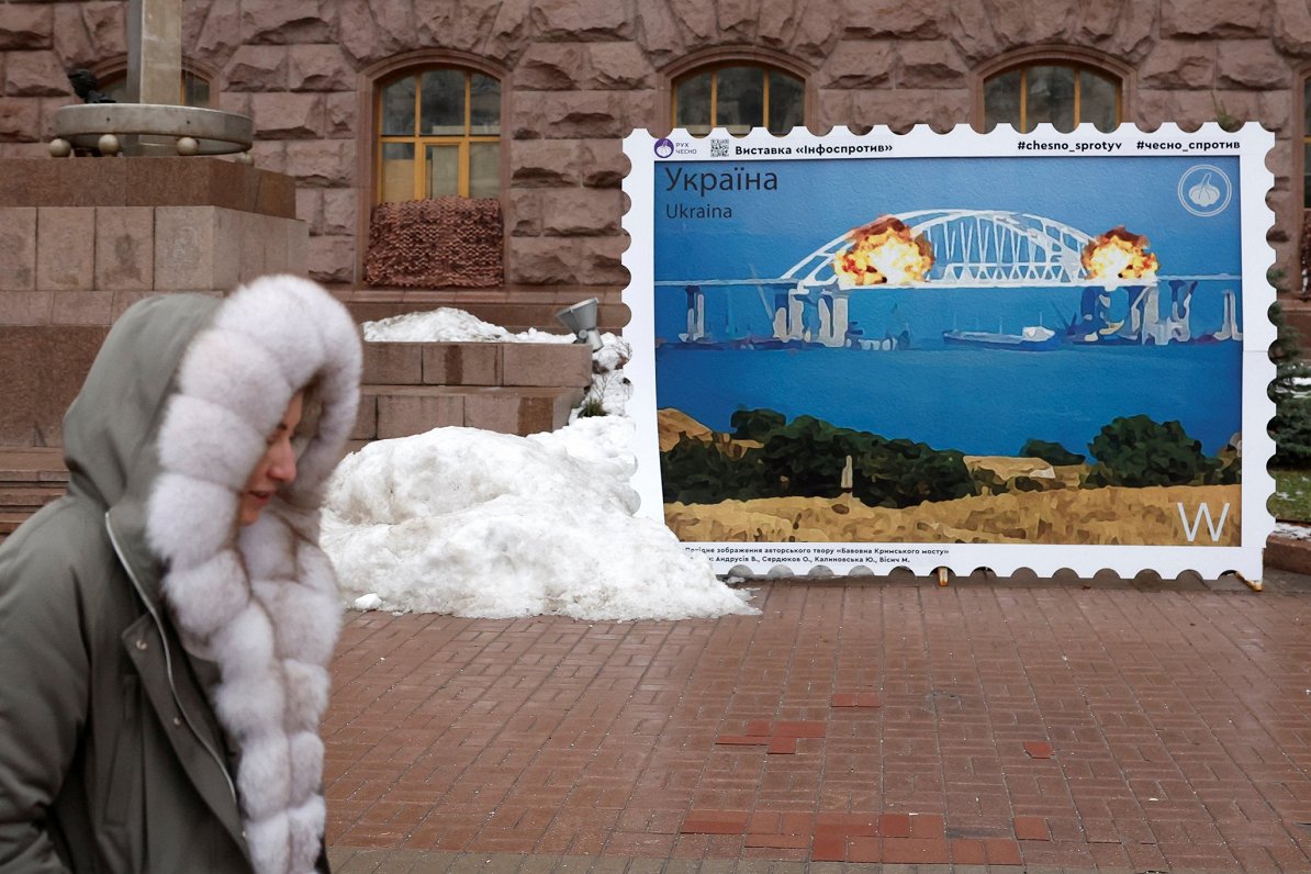 Ukrainas galvaspilsētā Kijivā redzams plakāts ar degoša Krimas tilta attēlu