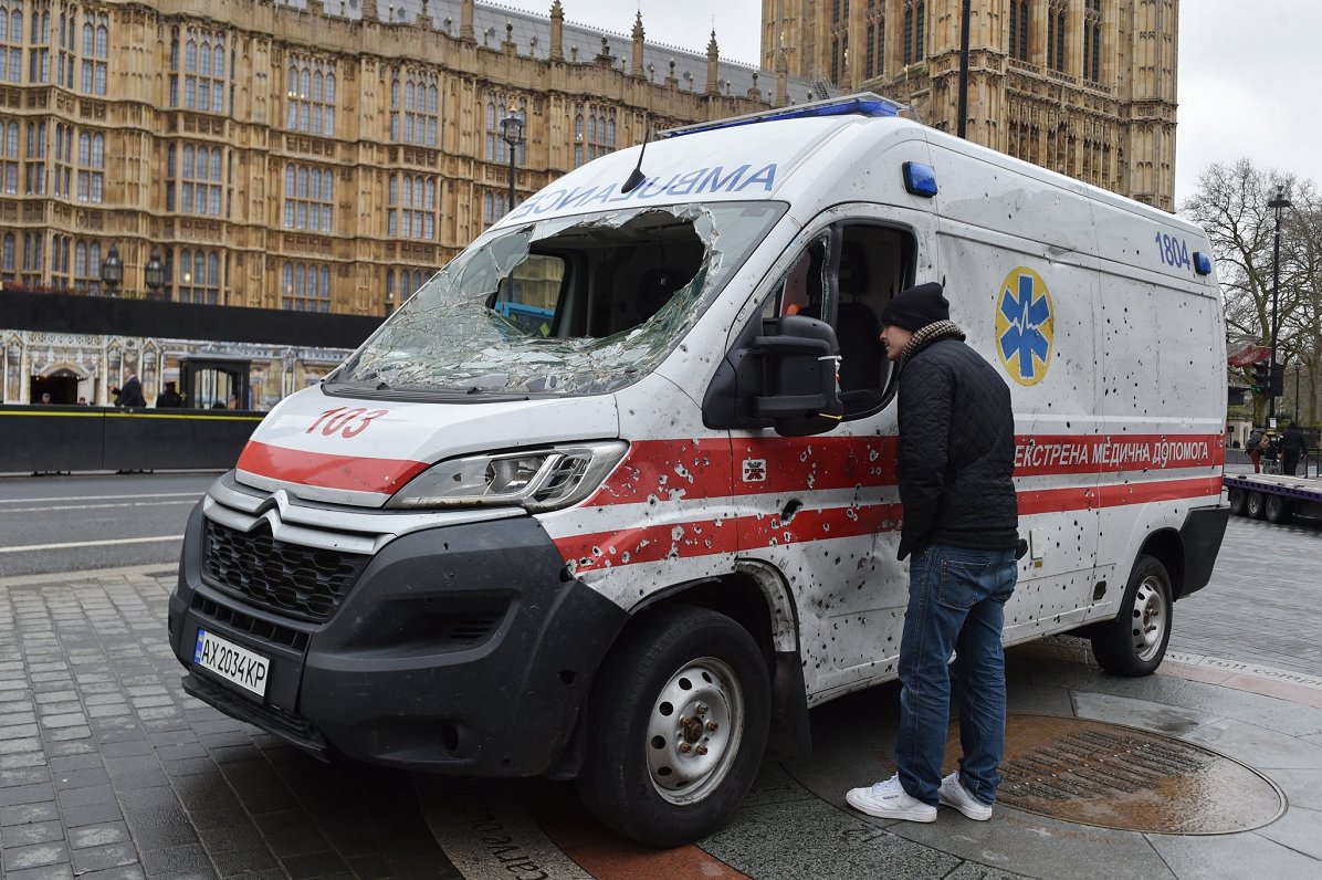 Ložu sacaurumota ātrās palīdzības mašīna pretī Londonas parlamenta ēkai.