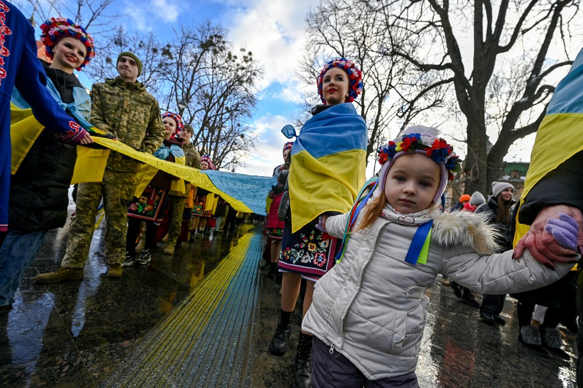 Ukrainas pilsētas Ļvivas iedzīvotāji ar milzīgu Ukrainas karogu, uz kura rakstīti novēlējumi ukraiņu...