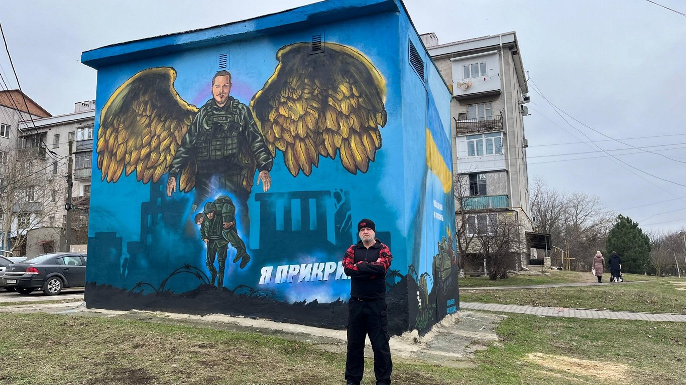 Олег Макаров на фоне мурала, посвященного его сыну