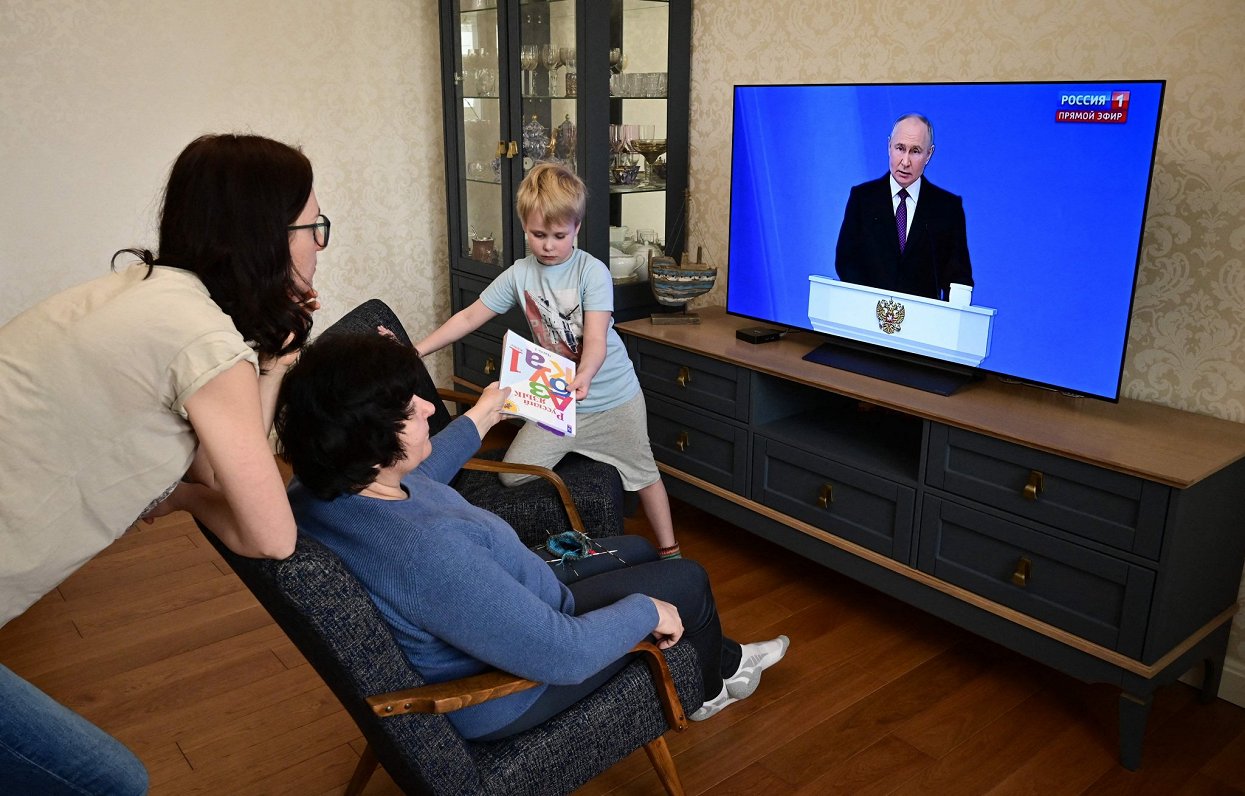 Krievijas iedzīvotāji skatās vadoņa Vladimira Putina uzrunu Krievijas parlamentam