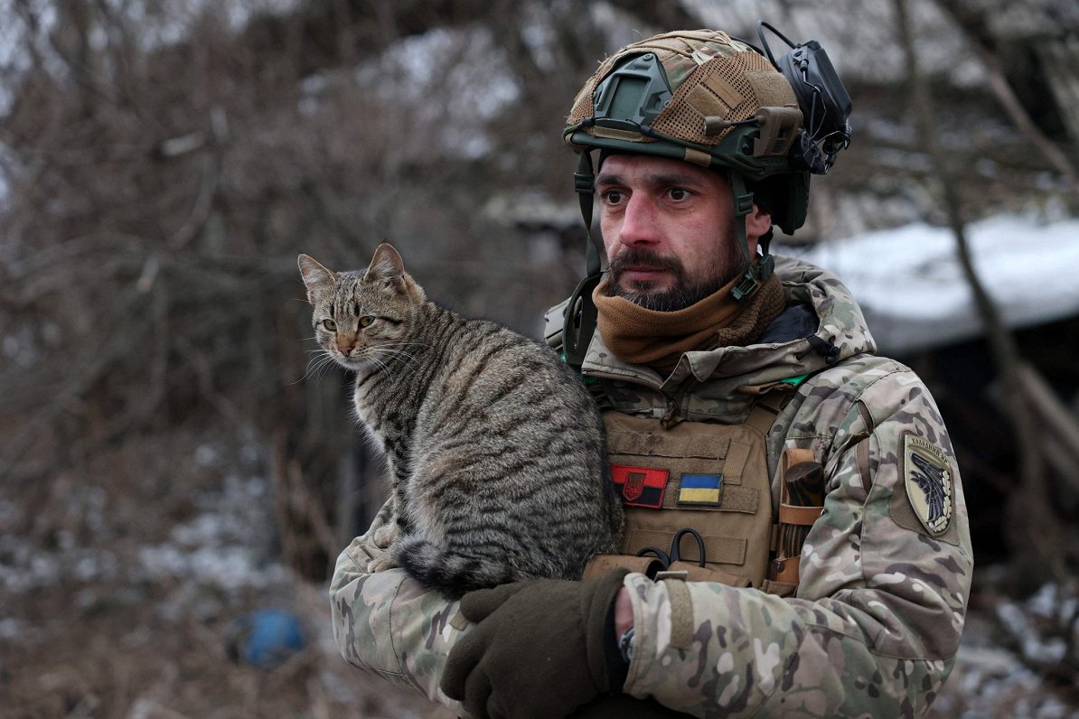 Ukrainas armijas karavīrs ar kaķi Bahmutas frontē.