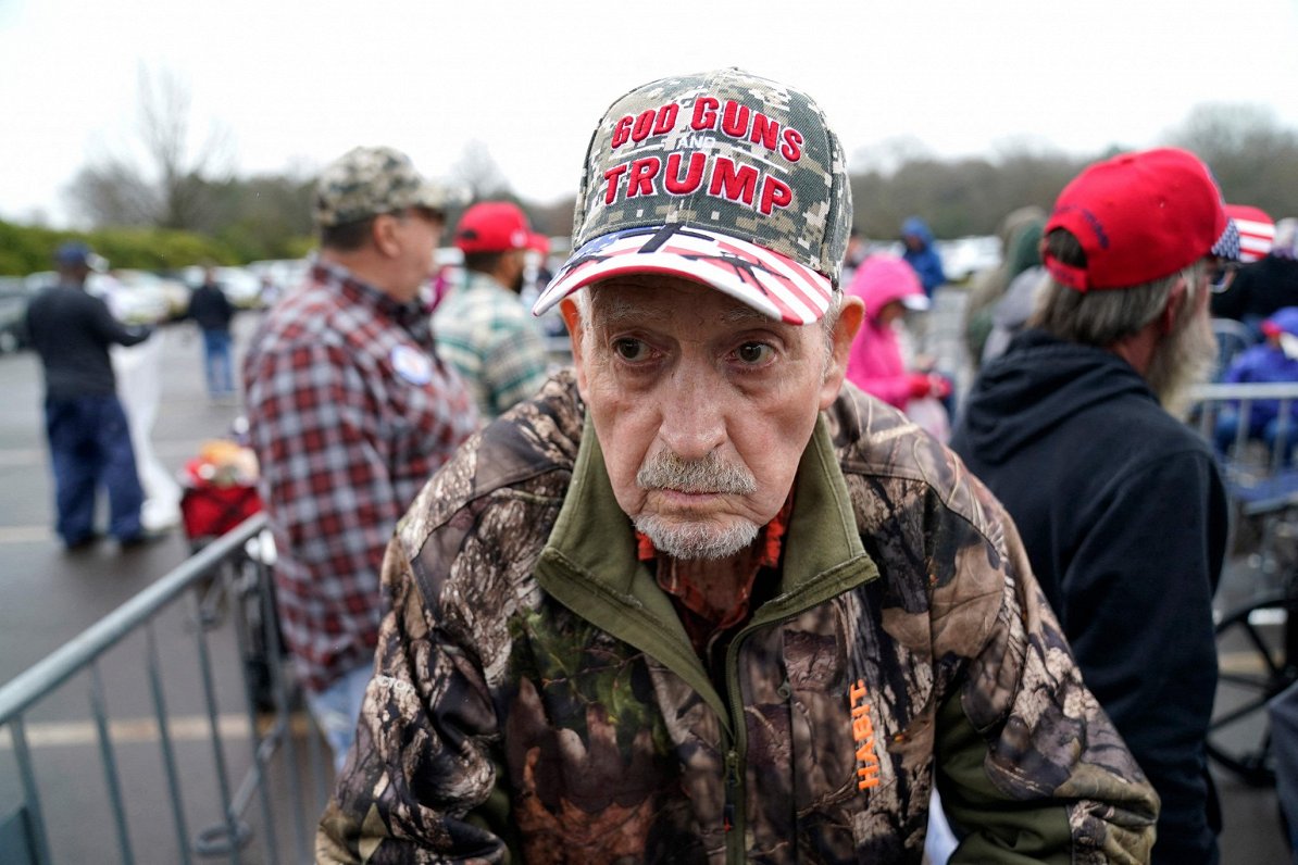 ASV eksprezidenta Donalda Trampa atbalstītājs ar cepurīti, kas vēsta &quot;Dievs. Ieroči. Tramps&quo...