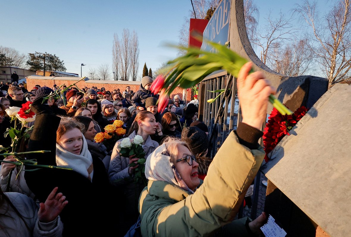 Cilvēki pulcējas pie slēgtajiem kapsētas vārtiem, lai noliktu ziedus uz opozicionāra Alekseja Navaļn...