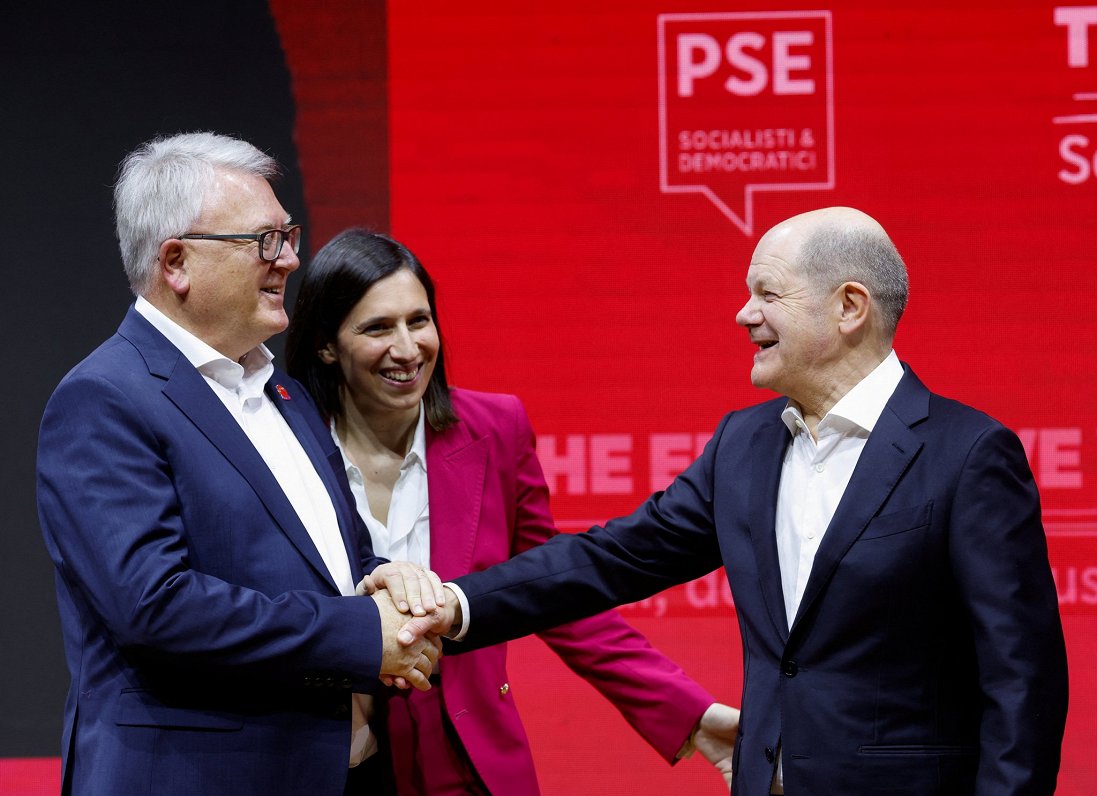 Eiropas sociāldemokrātu izvirzītais vadošais kandidāts Nikolā Šmits (no kreisās) sasveicinās ar Vāci...