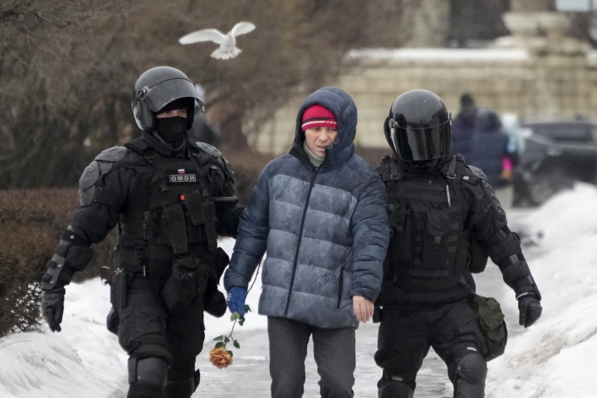 Krievijas policijas specvienības kaujinieki aiztur vīrieti, kurš bija atnācis nolikt ziedus, godinot...