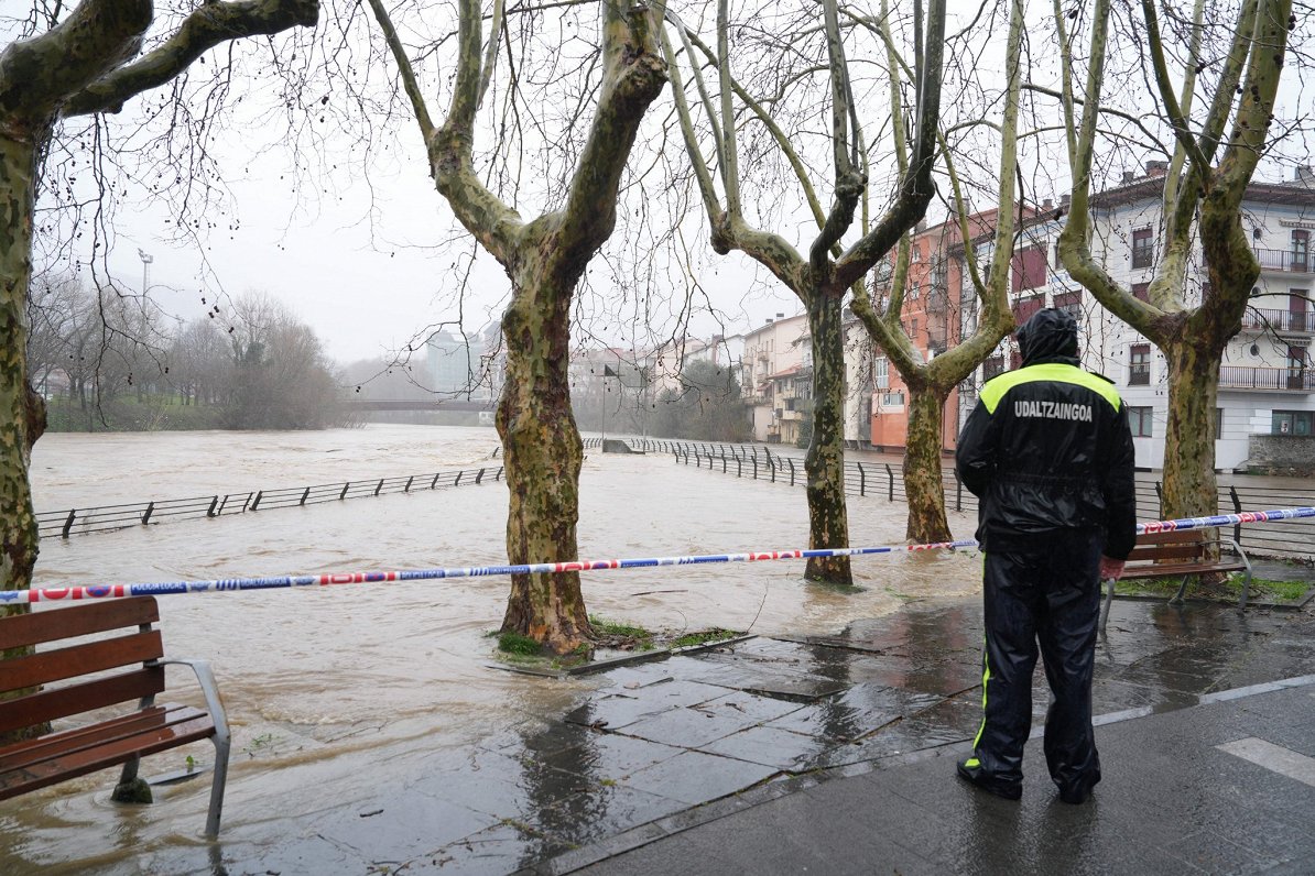 Basku zemē Spānijā vietējais policists vēro plūdu sekas. Klimata pētnieki brīdina, ka klimata pārmai...