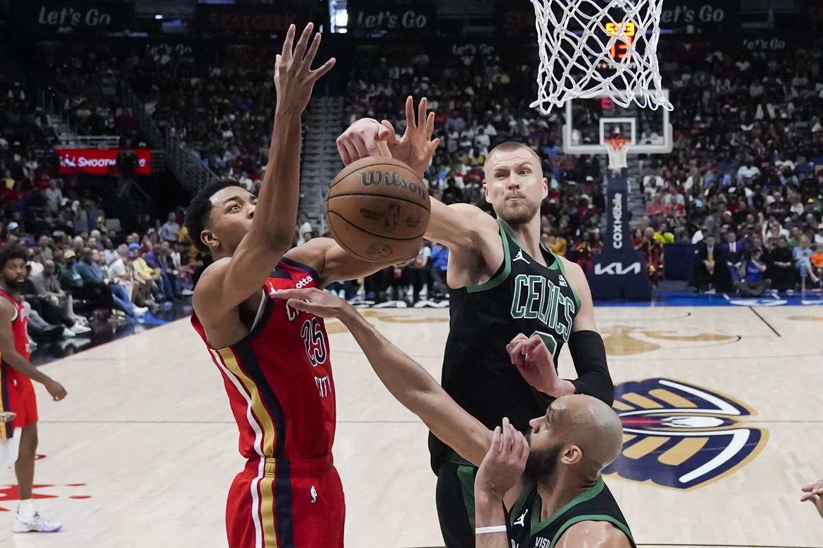 Bostonas &quot;Celtics&quot; basketbolists Kristaps Porziņģis (pa labi) bloķē Ņūorleānas &quot;Pelic...