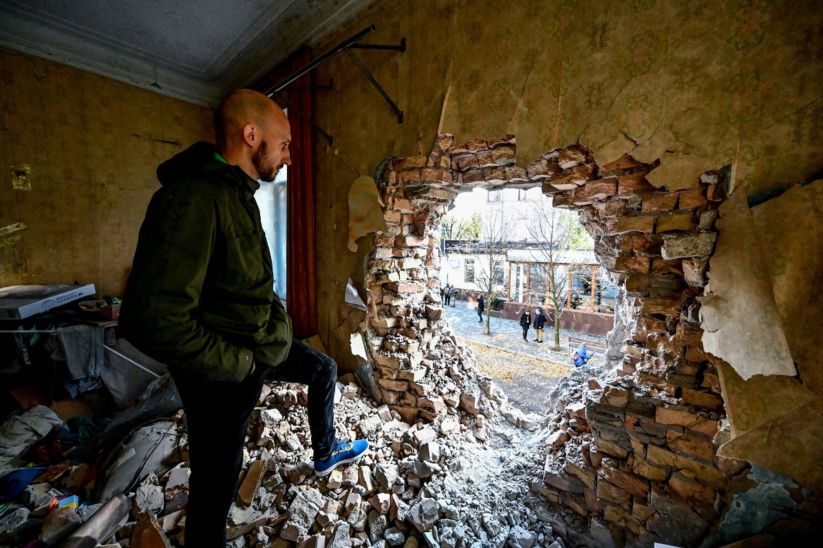 Ukrainas pilsētas Zaporižjas iedzīvotājs aplūko Krievijas veiktās apšaudes radītos bojājumus