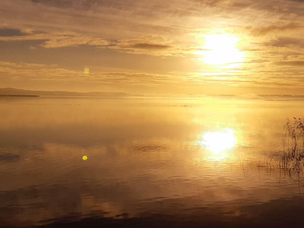 Saullēkts oktobra rītā virs Juglas ezera Strazdumuižas ciematā 2022. gadā.