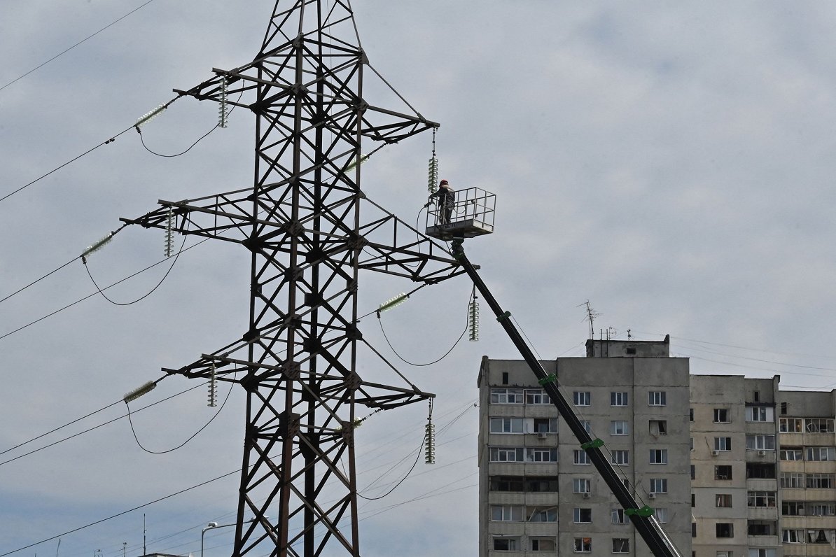Strādnieks labo Krievijas raķešu uzbrukumā bojāto elektroapgādes līniju Ukrainas pilsētā Harkivā
