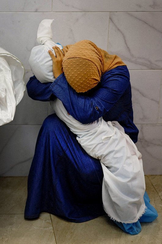 Gazas slimnīcas morgā palestīniešu sieviete Inasa Abu Māmara sēro ar piecgadīgās māsasmeitas Salijas...
