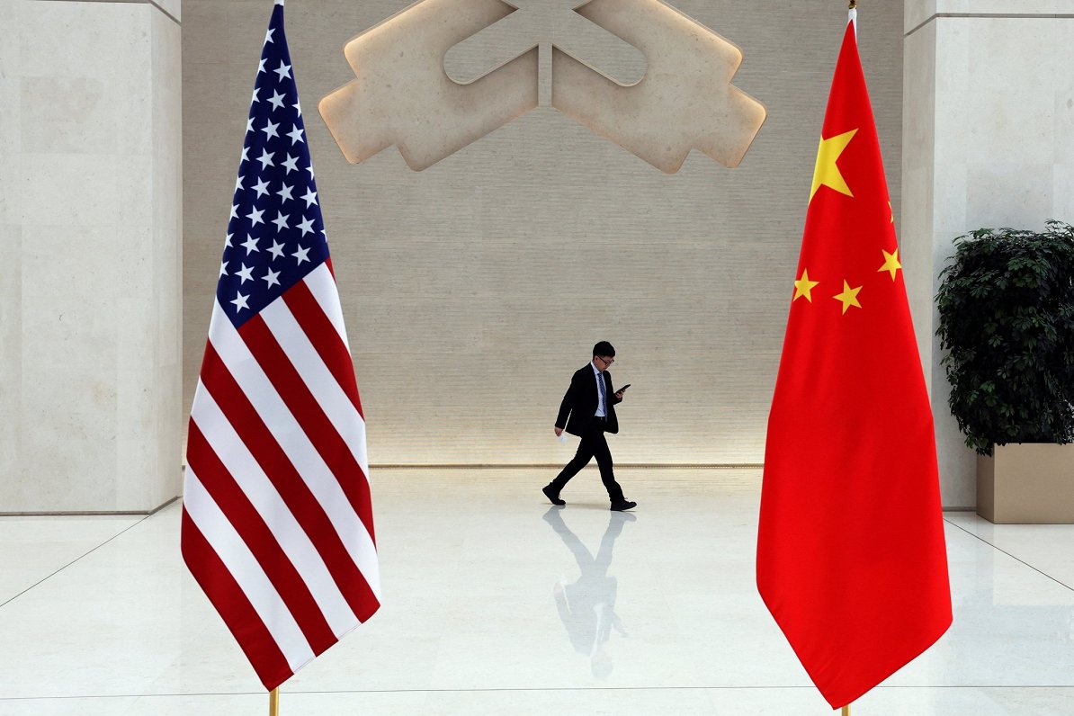 Ilustratīvs attēls: ASV un Ķīnas karogi Ķīnas Tautas Republikas Centrālajā bankā Pekinā