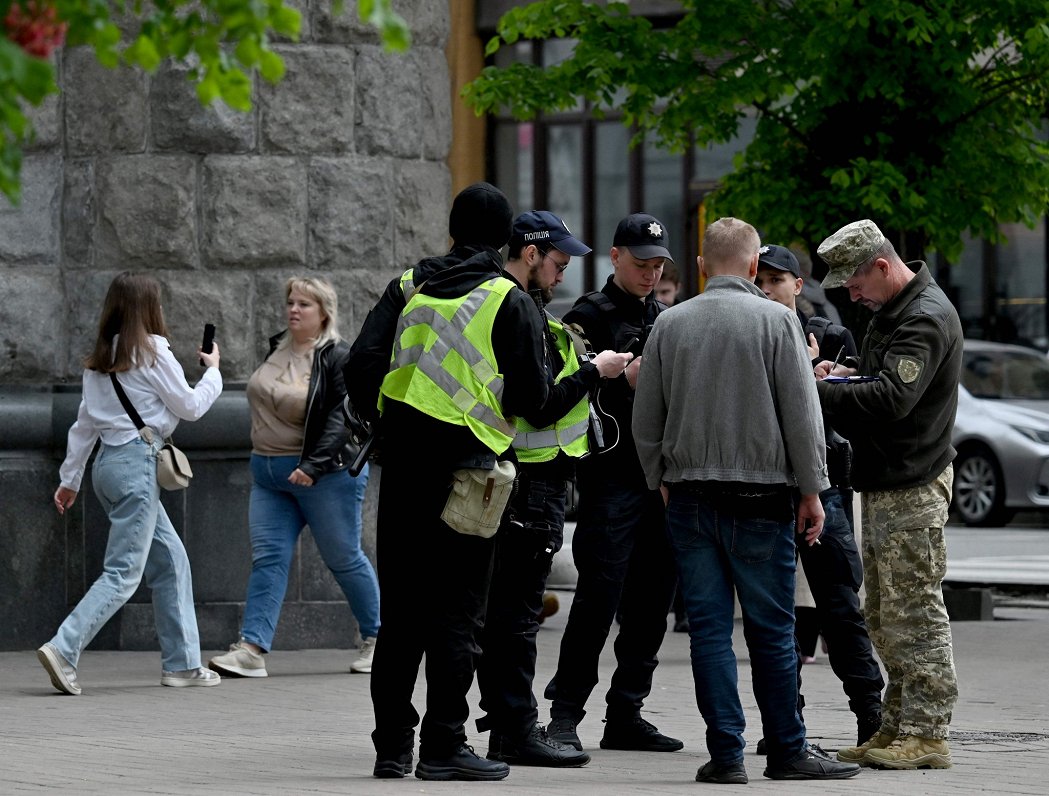 Ukrainas karavīri un policisti veic dokumentu pārbaudi Kijivā.