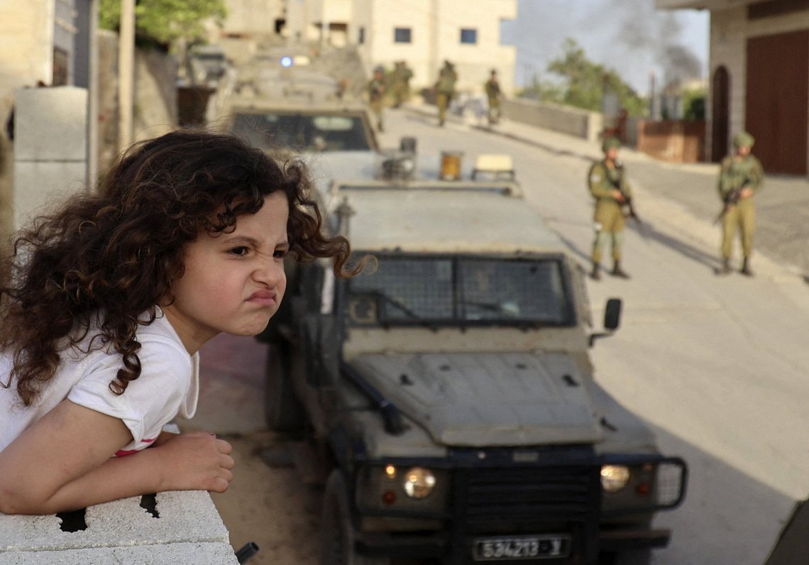 Palestīniešu meitene vēro Izraēlas karaspēka operāciju Rietumkrastā