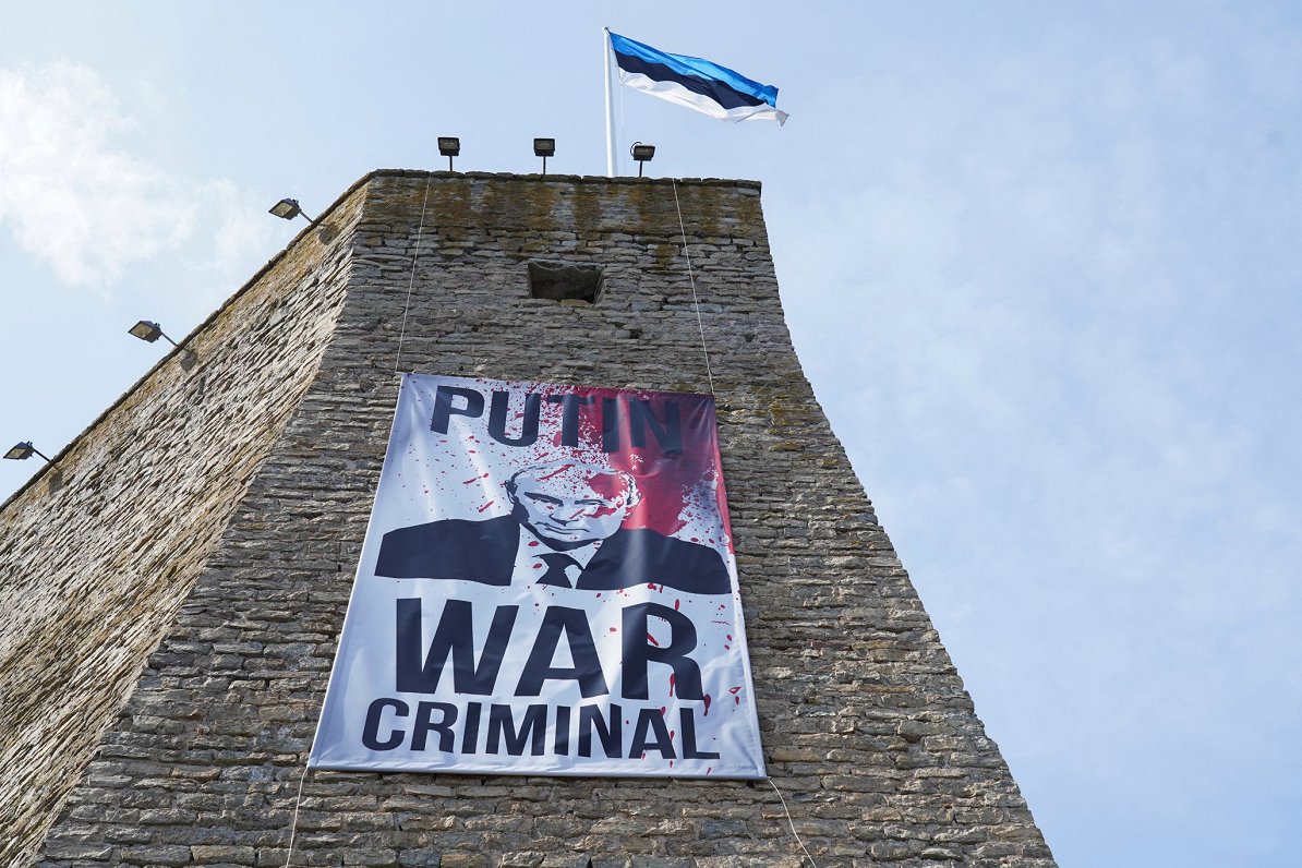 Narvā pie Hermaņa pils karoga torņa izkārtais plakāts ar Krievijas prezidenta Vladimira Putina attēl...