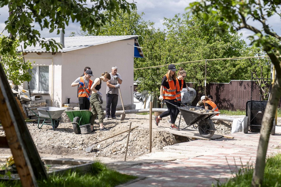 Brīvprātīgie atjauno Ukrainas iedzīvotāju mājas.