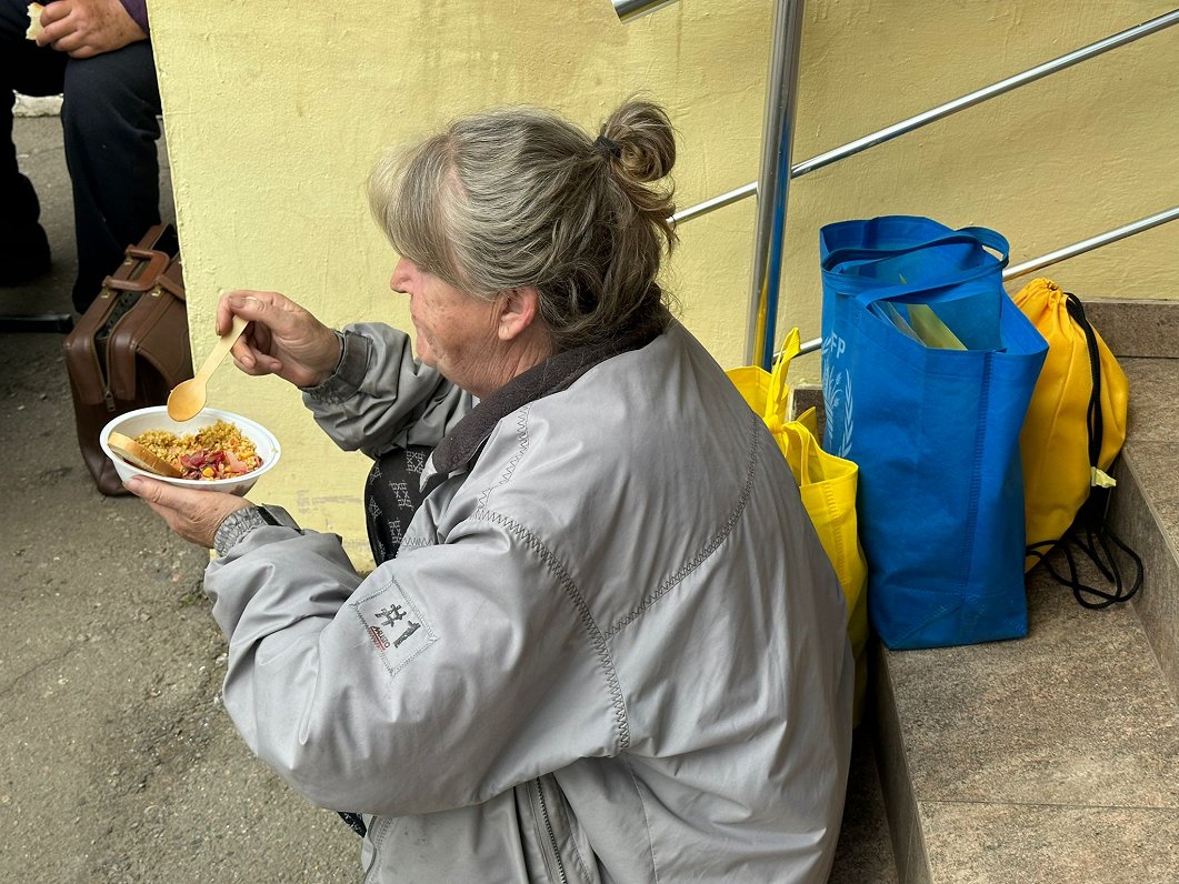 Sieviete saņem maltīti kara bēgļu atbalsta punktā Harkivā