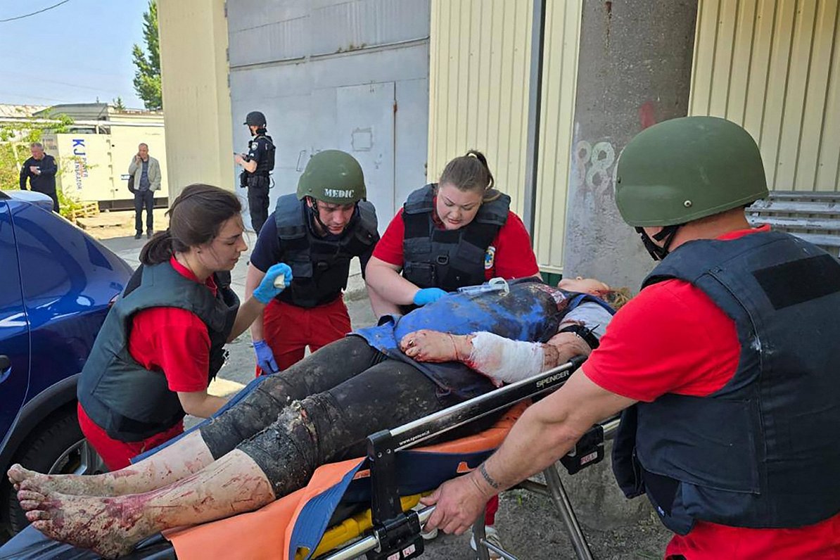Ukrainas pilsētā Harkivā mediķi sniedz palīdzību Krievijas raķešu uzbrukumā ievainotai sievietei