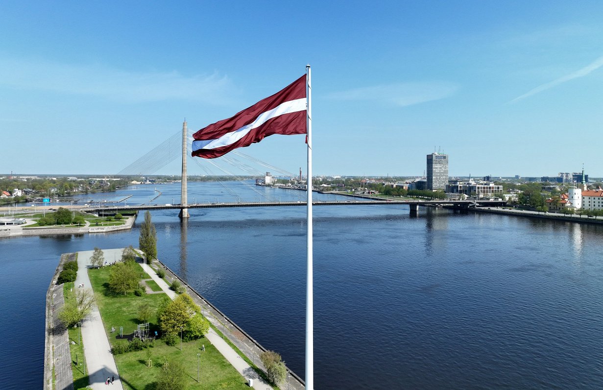 Latvijas karogs uz uz AB dambja un Vanšu tilts.