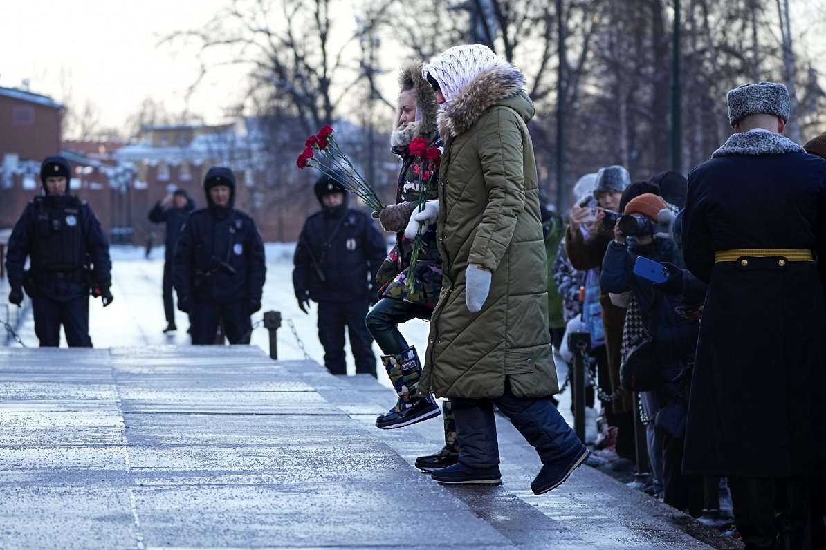 Krievijas mobilizēto karavīru sievas noliek ziedus pie nezināmā karavīra kapa Maskavā