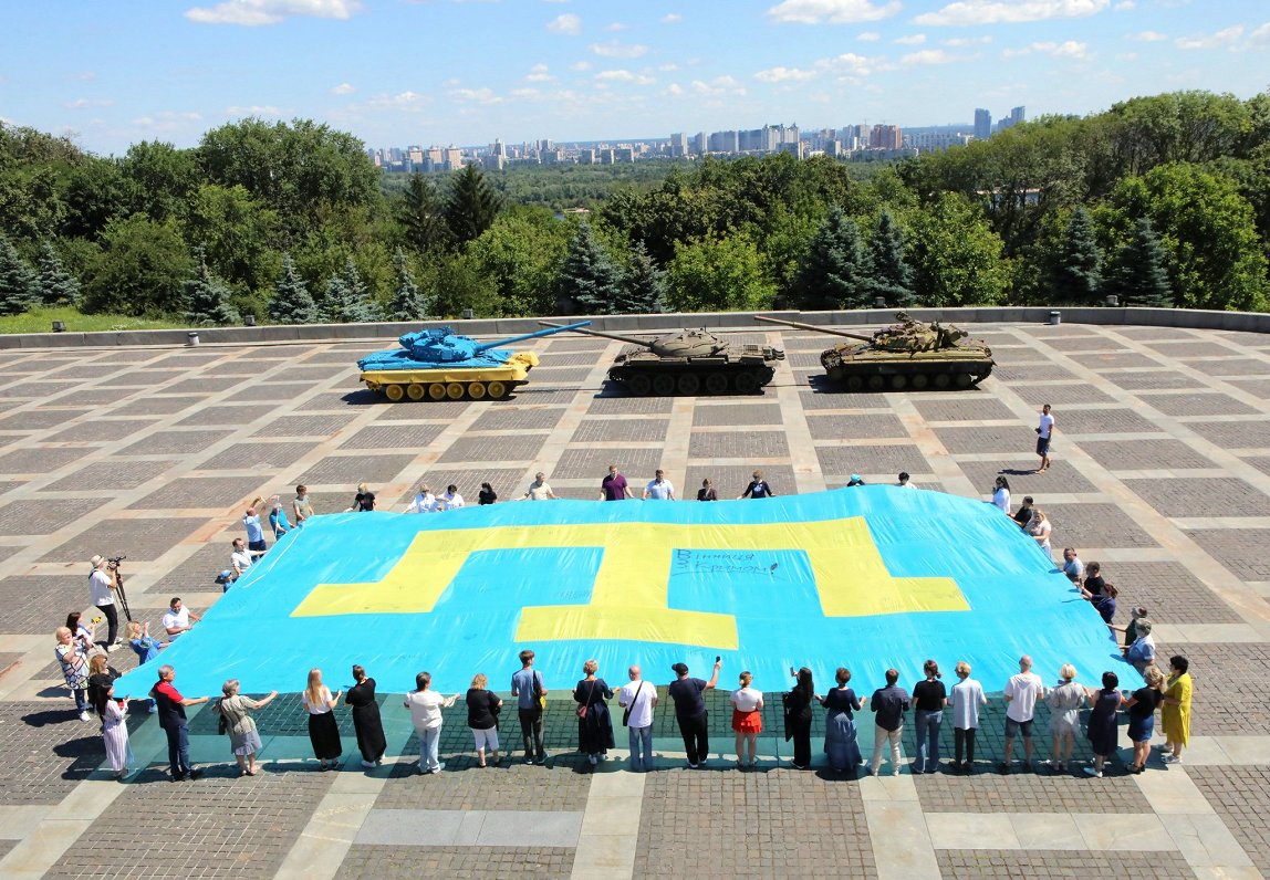 Cilvēki pulcējas, lai uzstādītu valsts rekordu par lielāko Krimas tatāru karogu Ukrainā.