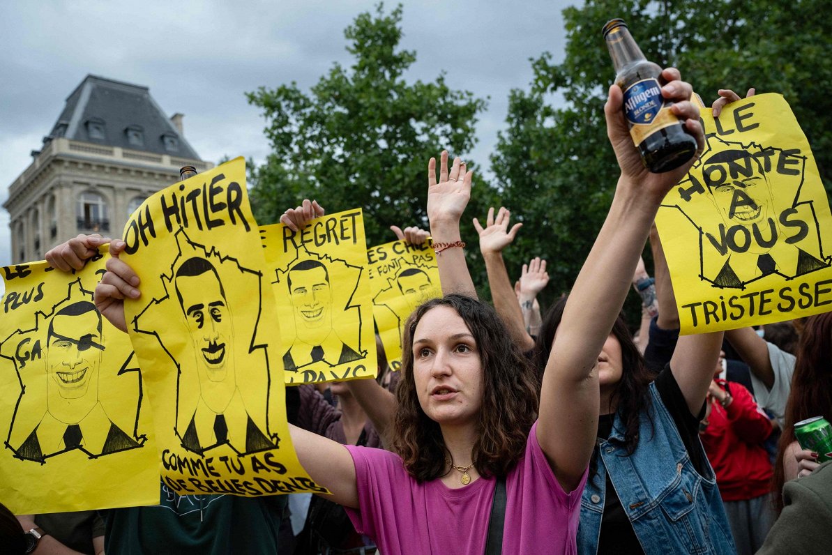Francijas galēji labējo spēku pretinieki demonstrācijā Parīzē demonstrē plakātus, kuros &quot;Nacion...