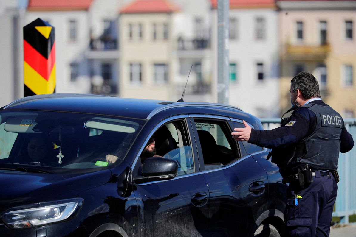 Vācu policists pārbauda dokumentus uz Polijas-Vācijas robežas.