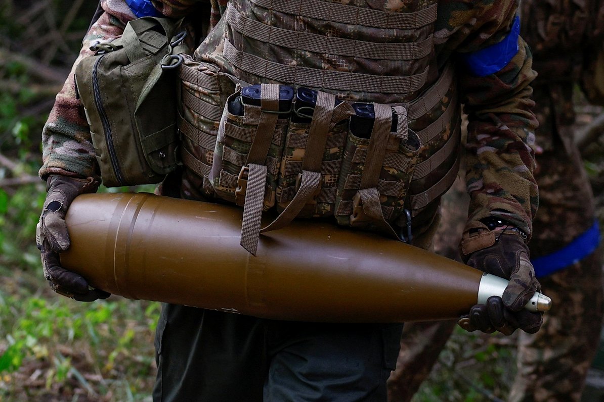 Ukrainas karavīrs ar artilērijas lādiņu